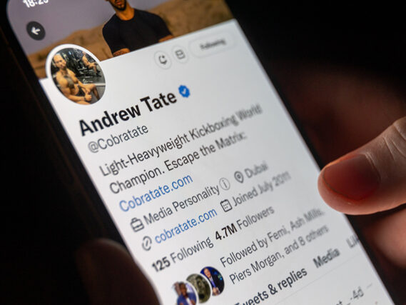 Sur cette photo, un homme regarde son téléphone et affiche la page Twitter d'Andrew Tate sur les réseaux sociaux.